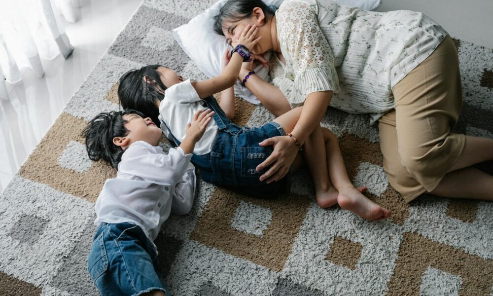 cheerful children lying on floor with mother